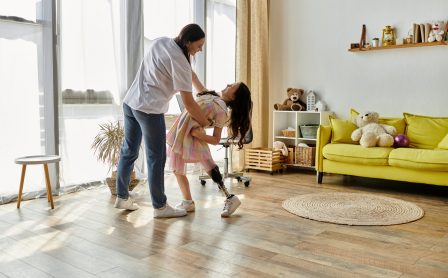 A mother and her daughter, who has a prosthetic leg, share a joyful moment of play at home.